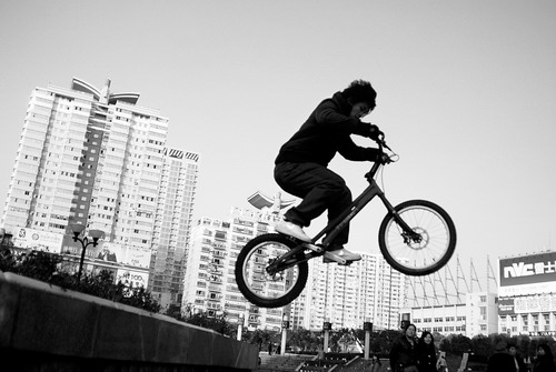 １月３日，刘安西俊在五一广场表演攀爬自行车，引得路人驻足观看。图／肖石平