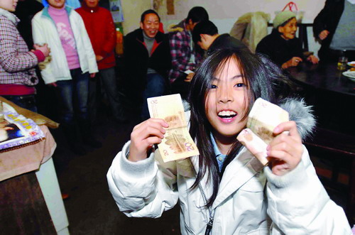 接过爷爷红包的贺梅,高兴地向亲戚展示自己收到的礼物。图/实习记者陈勇